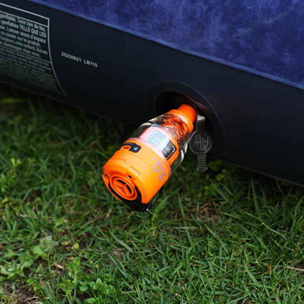 Nomadia Accessory High Speed 2-in-1 Rechargeable Air Pump pumping air mattress on grassy land - camping essential - uk camping