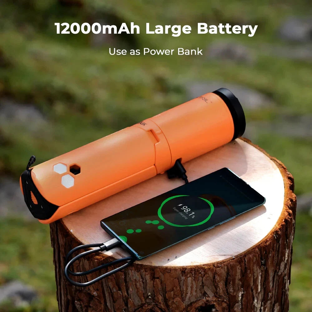 Orange Nomadia Accessory OuTask x FLEXTAIL Telescopic Camping Lantern used as power bank with 12000mAh capacity charging a smartphone on a wooden stump outdoors - multi-use -multi-purpose light -camping gear - uk camping