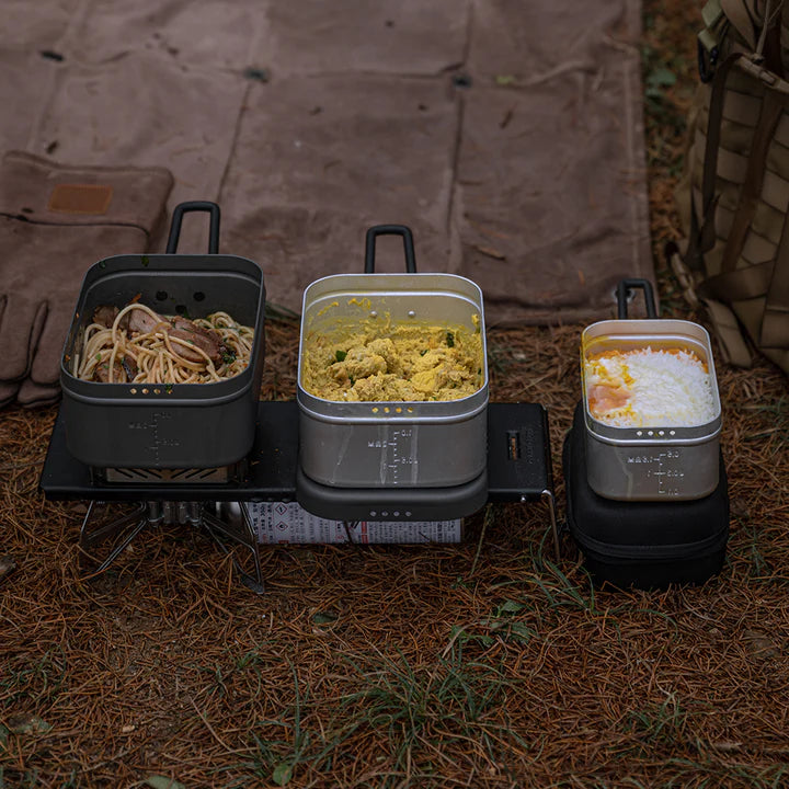 Portable outdoor cooking setup with Nomadia CampStation Outdoor Aluminium Lunch Box on a camping stove - outdoor cooking - camping gear - camping essential
