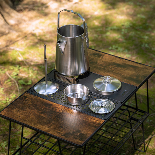 Camping stove with Nomadia CampStation Stainless Steel Coffee Pot on a wooden modular camping table outdoors - outdoor cooking -