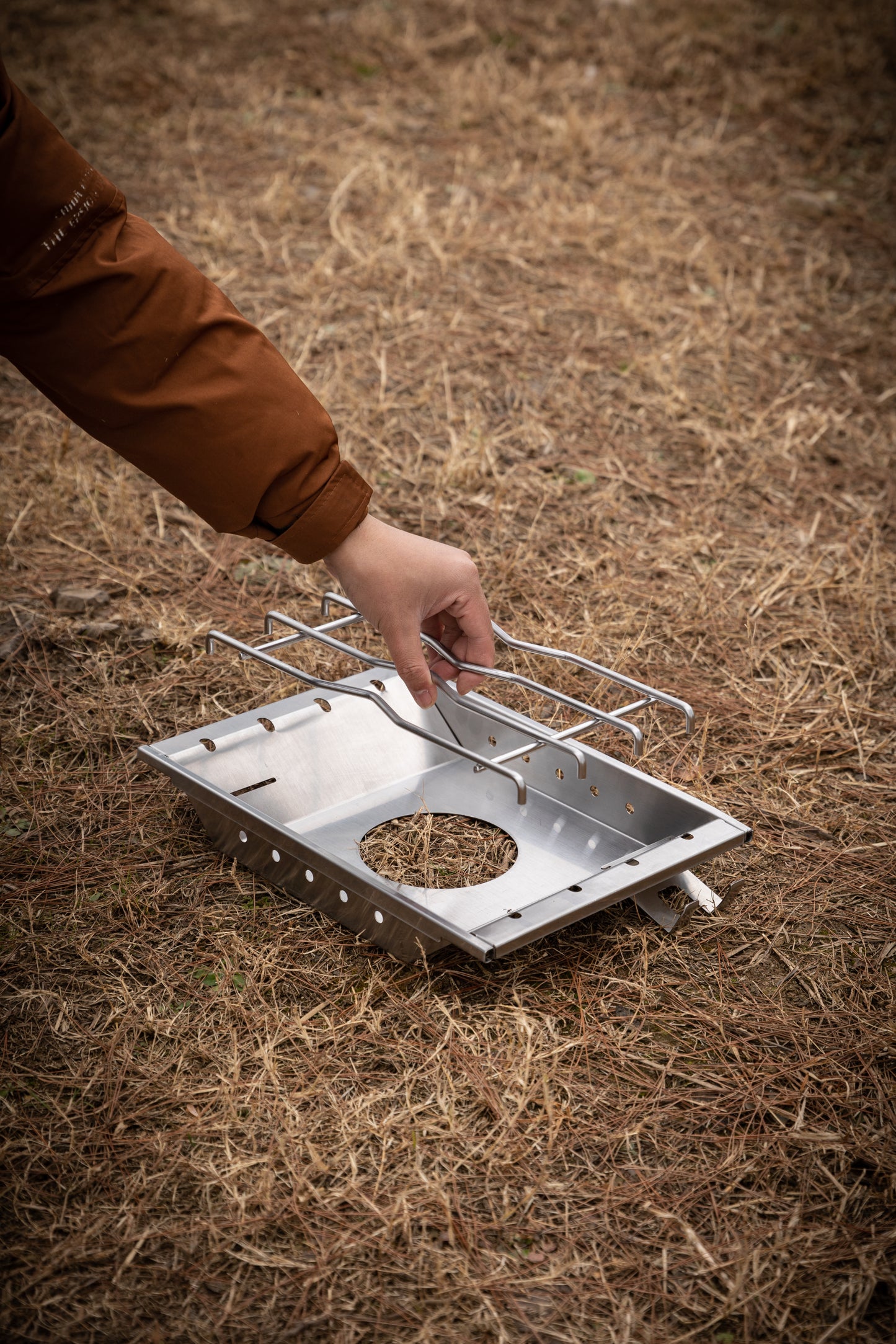 setting up a portable camping stove on dry grass with Nomadia CampStation Stove Set - removable rack - detachable metal rack - uk camping