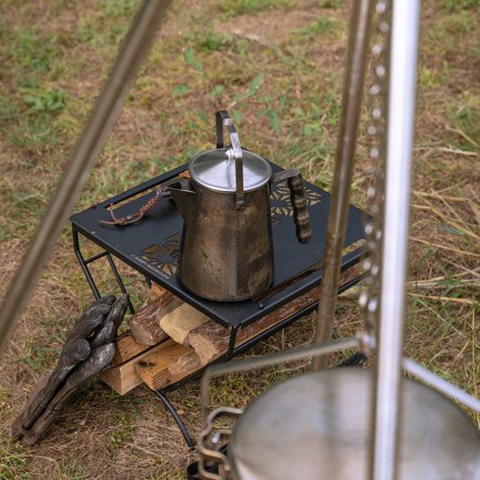 Nomadia Flamo Crafted Camping Kettle on a small camping table - camping essential - atmospheric