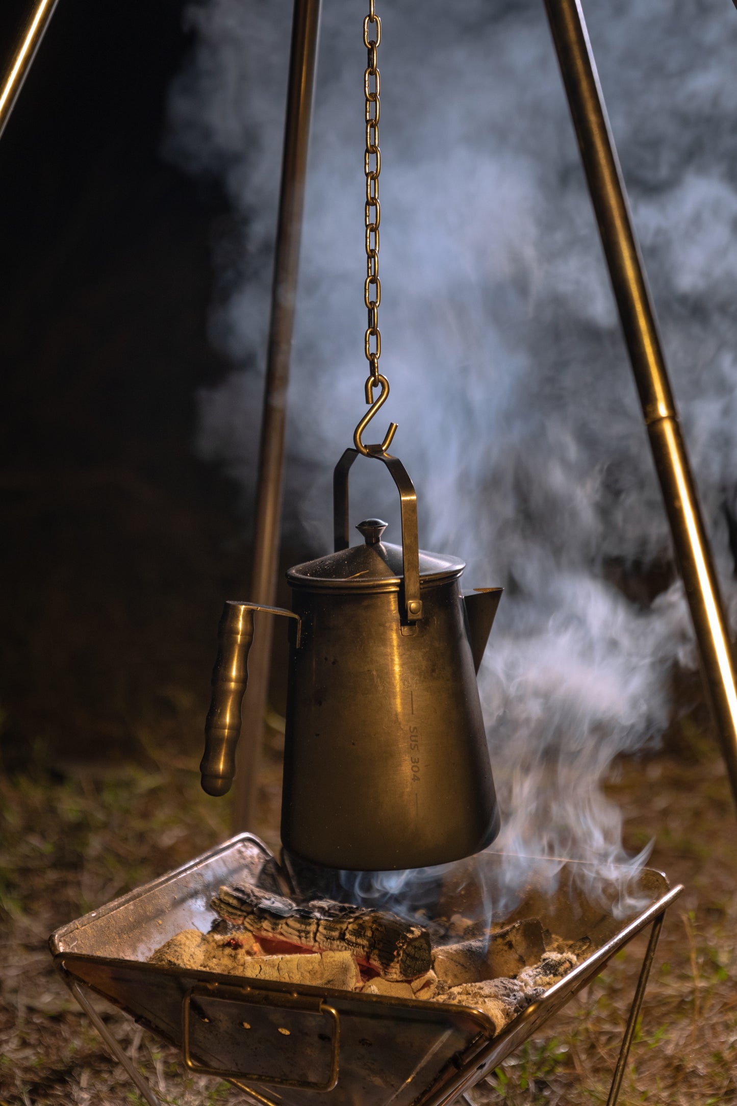 Nomadia Flamo Crafted Camping Kettle hanging over a campfire with smoke - camping with fire - wild camping