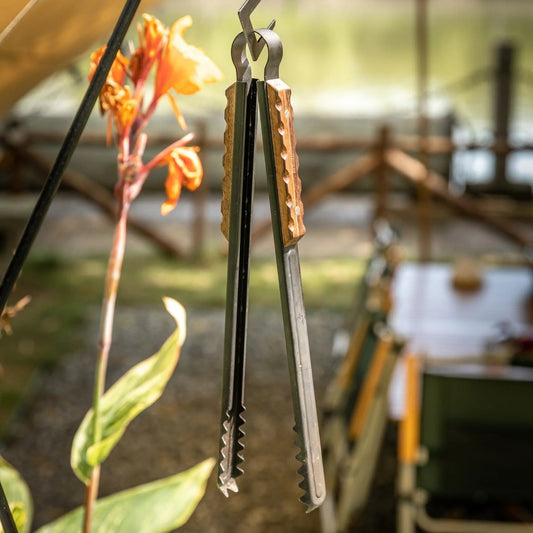 Nomadia Flamo Wood Handle Outdoor Heavy-Duty Outdoor Tongs hanging on a hook- camping gear - BBQ Grill accessory