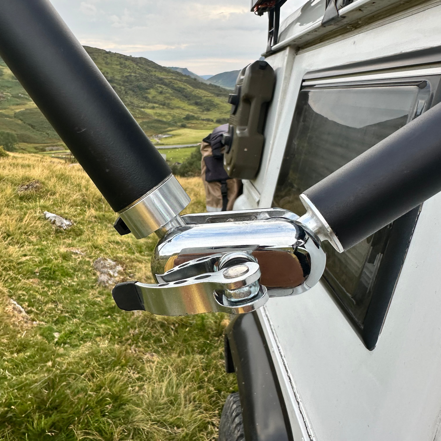 Close-up of a vehicle roof rack system Nomadia FlexMount Suction Arm with a scenic background - camping and survival
