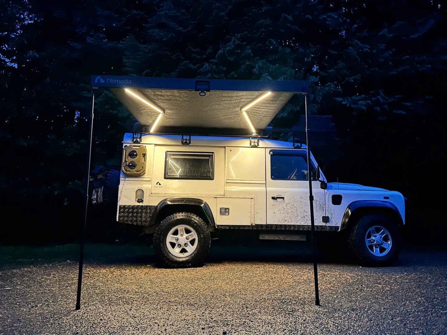 Nomadia Glide World's fastest opening awning with build-in light in raining forest setting - overlanding - wildcamping - aluminium awning - easy setup - fast setup awning - all weather ready