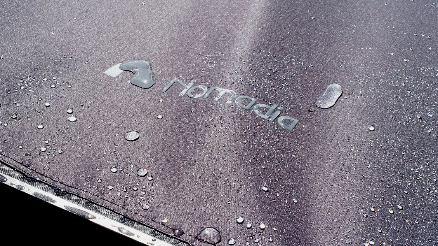 Close-up of Nomadia Glide World's fastest opening awning under rain - all weather ready - durability - overlanding - wildcamping - aluminium awning - easy setup - fast setup awning - strong support