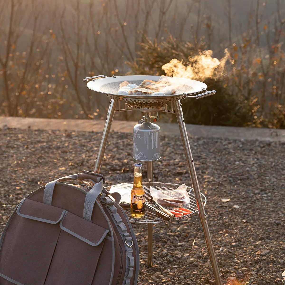 Outdoor cooking setup with aNomadia Horizon Cook portable outdoor cooking station for sharing on a gravel surface with compatible storage bag included - - portable grill pan - outdoor cookware for groups - multi-function camping stove - camp kitchen - cookware for camping