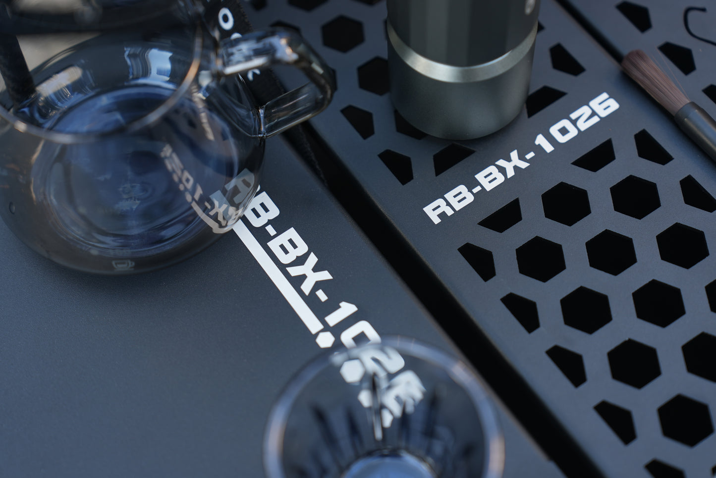 Close-up of a coffee brewing setup using Nomadia ModoBox 2in1 camping table and storage box with a glass carafe and a black metal tray