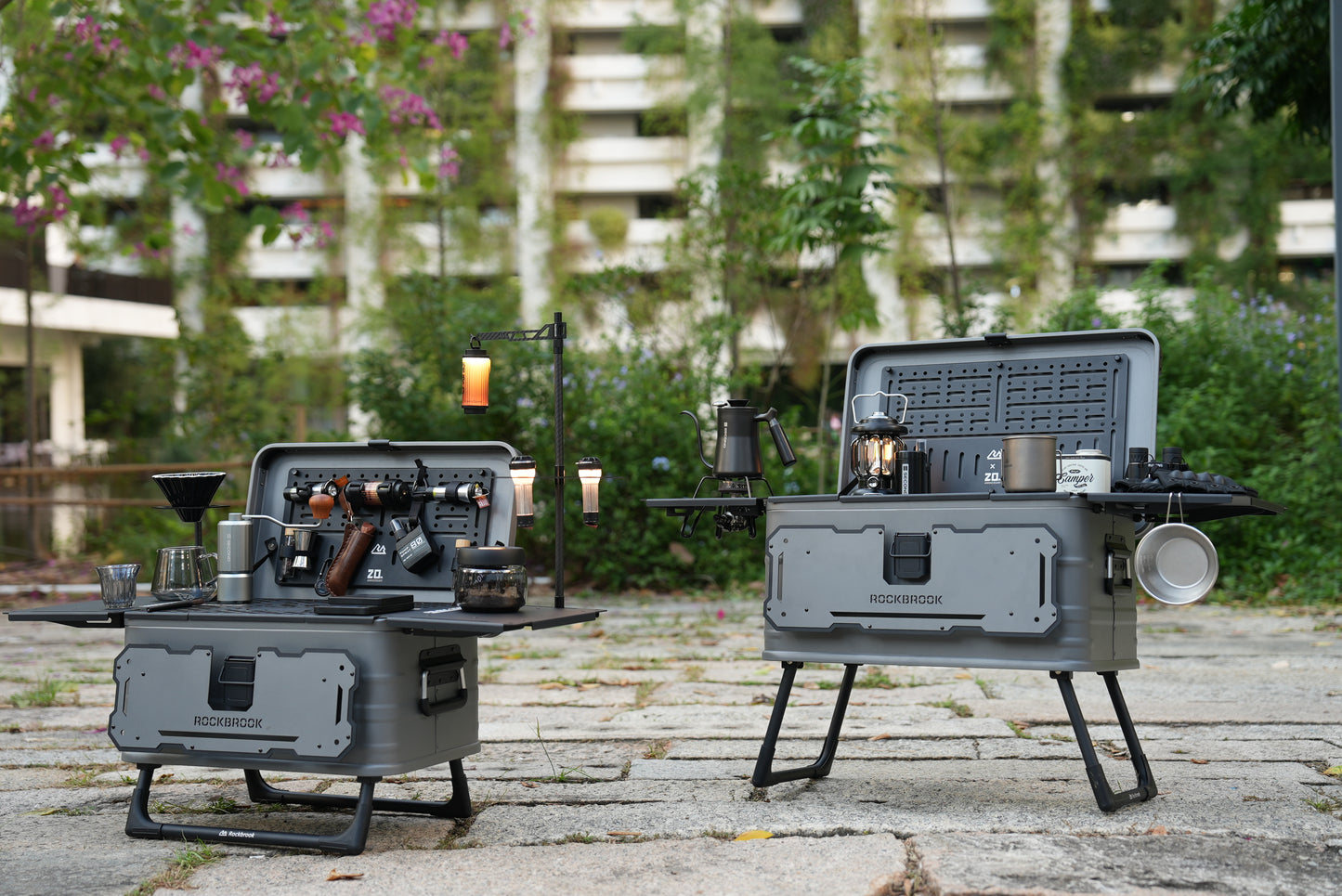 30L and 50L Nomadia ModoBox 2in1 camping table and storage box with accessories on a rough surface outdoors - camping gear - glamping - uk camping