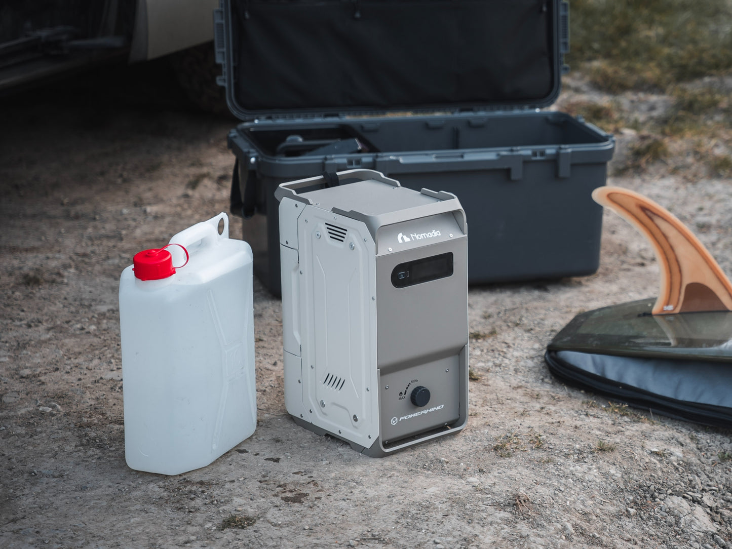 thermoflow - nomadia's Portable heated shower system with a fuel canister and a carton of water with surfing board on rough surface - wildcamping - outdoor use - uk camping - outdoorsy