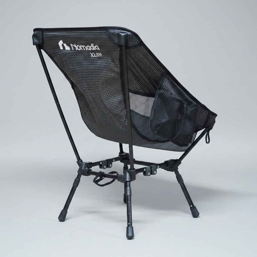 Black camping chair with mesh back and 'Nomad' branding on a gray background