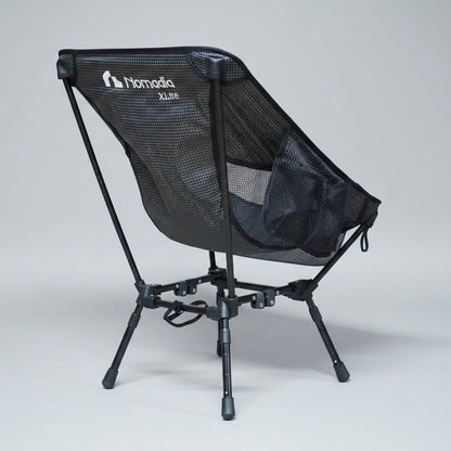 Black camping chair with mesh back and 'Nomad' branding on a gray background