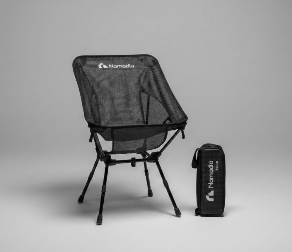 Black camping chair with carrying bag on a gray background