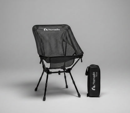 Black camping chair with carrying bag on a gray background