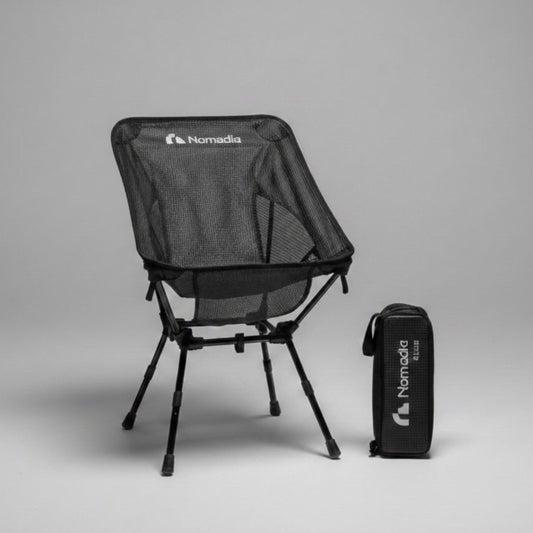Black camping chair with carrying bag on a gray background