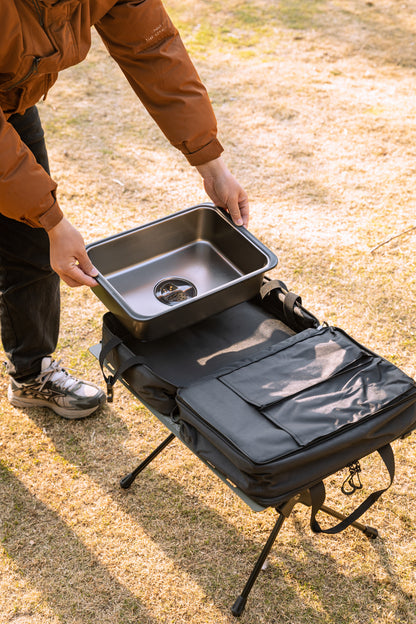 person placing Nomadia CampStation Kitchen Sink into storage bag - portable camping gear - outdoor cooking equipment - easy storage 