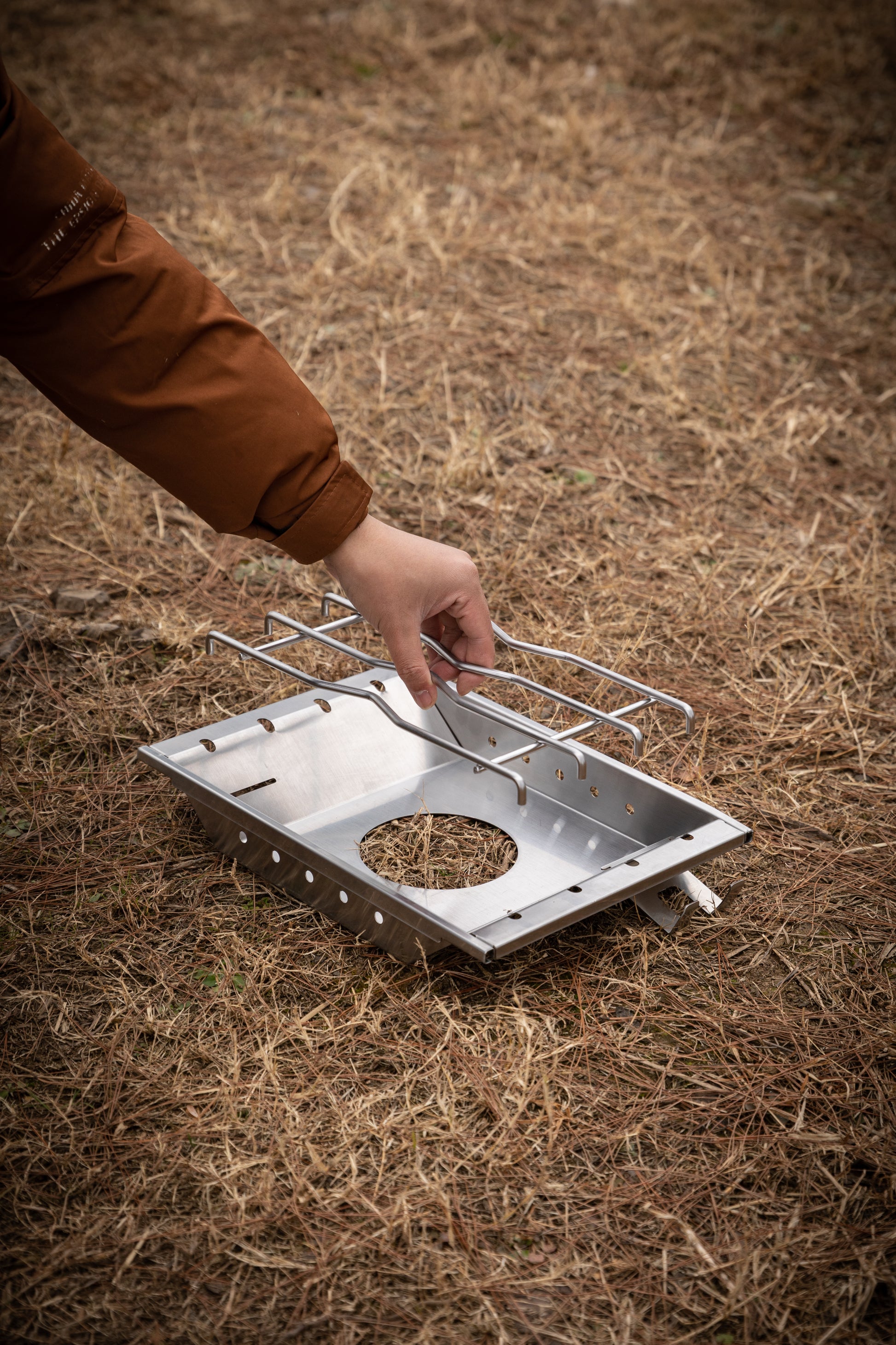 setting up a portable camping stove on dry grass with Nomadia CampStation Stove Set - removable rack - detachable metal rack - uk camping