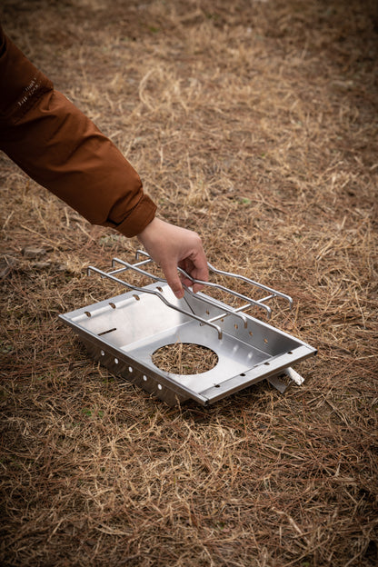 setting up a portable camping stove on dry grass with Nomadia CampStation Stove Set - removable rack - detachable metal rack - uk camping