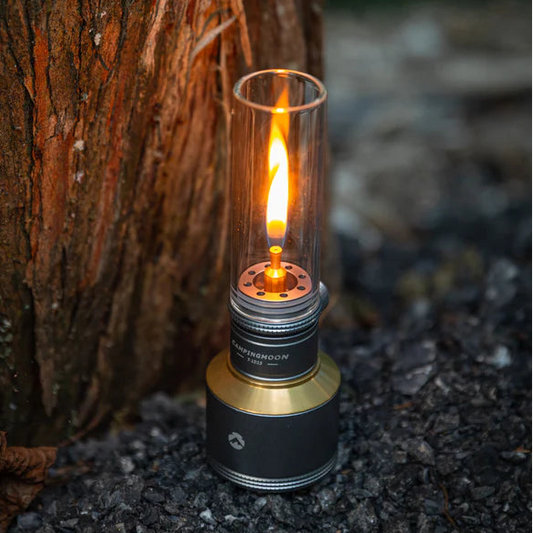 Flickering Nomadia Camping Light Candle-Style Gas Camping Lamp Set  against a tree trunk in a natural setting - camping with a fire - uk camping - atmospheric light