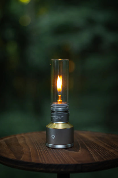 Flickering Nomadia Camping Light Candle-Style Gas Camping Lamp Set on a wooden surface - camping with a fire - uk camping - atmospheric light