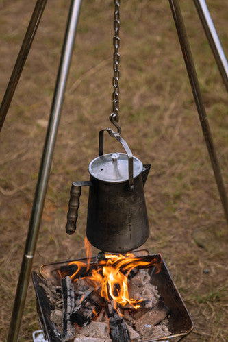 Nomadia Flamo Crafted Camping Kettle hanging on top of burning fire pit - camping accessory - camping essential - atmospheric -camping with fire - wildcamping