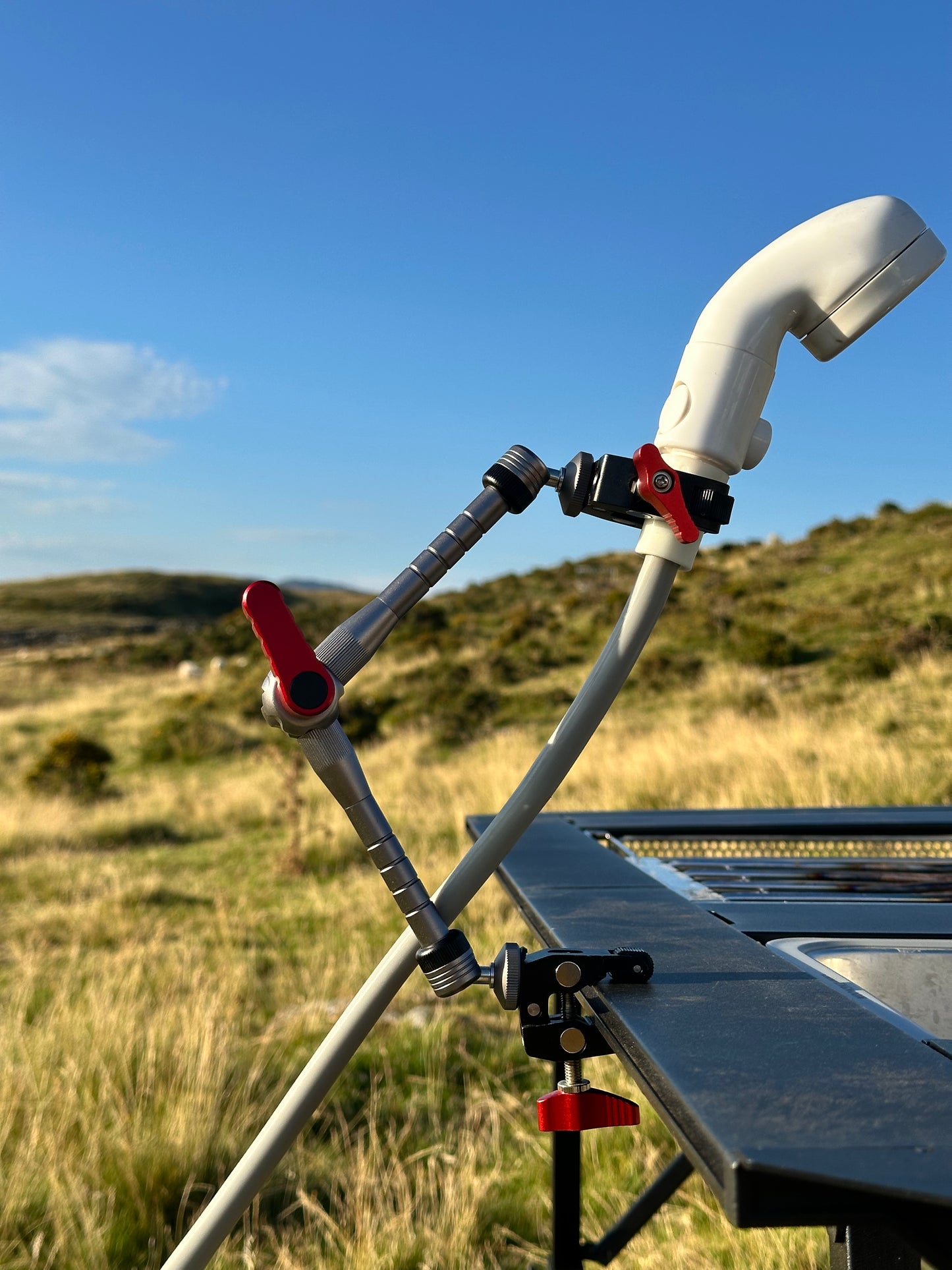 Nomadia FlexArm Dual Clamp used to hold shower head from thermoflow and table for easy showing outdoor - multi-use camping gear 