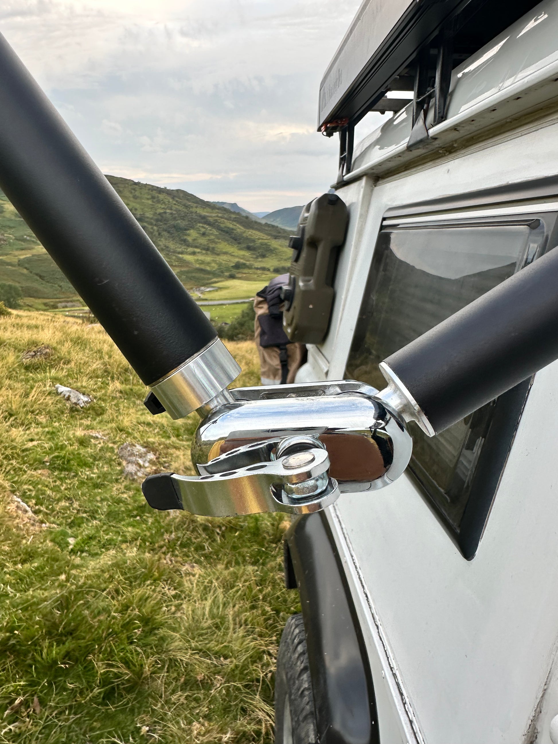 Close-up of a vehicle roof rack system Nomadia FlexMount Suction Arm with a scenic background - camping and survival