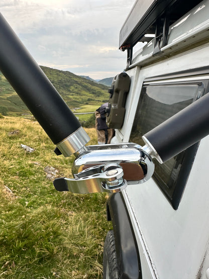 Close-up of a vehicle roof rack system Nomadia FlexMount Suction Arm with a scenic background - camping and survival