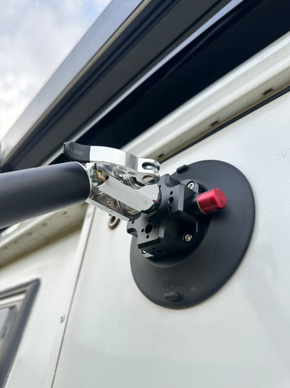 Close-up of a vehicle roof rack mount Nomadia FlexMount Suction Arm on a white van with a cloudy sky background - camping and survival - 