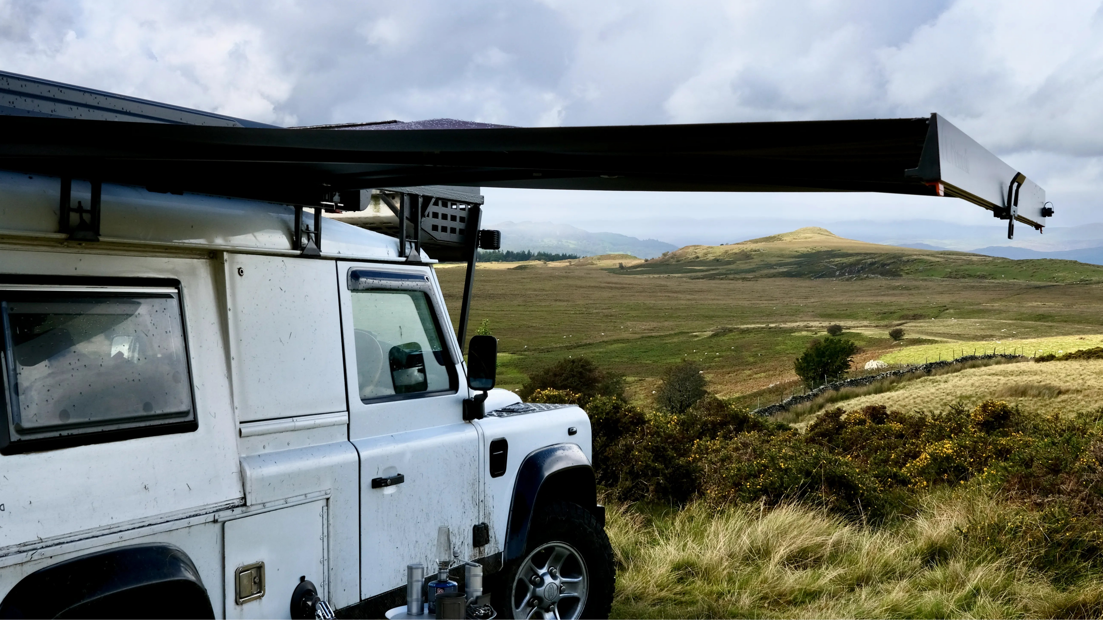 White off-road vehicle with Nomadia Glide World's fastest opening awning in a scenic landscape - overlanding - wildcamping - aluminium awning - easy setup - fast setup awning