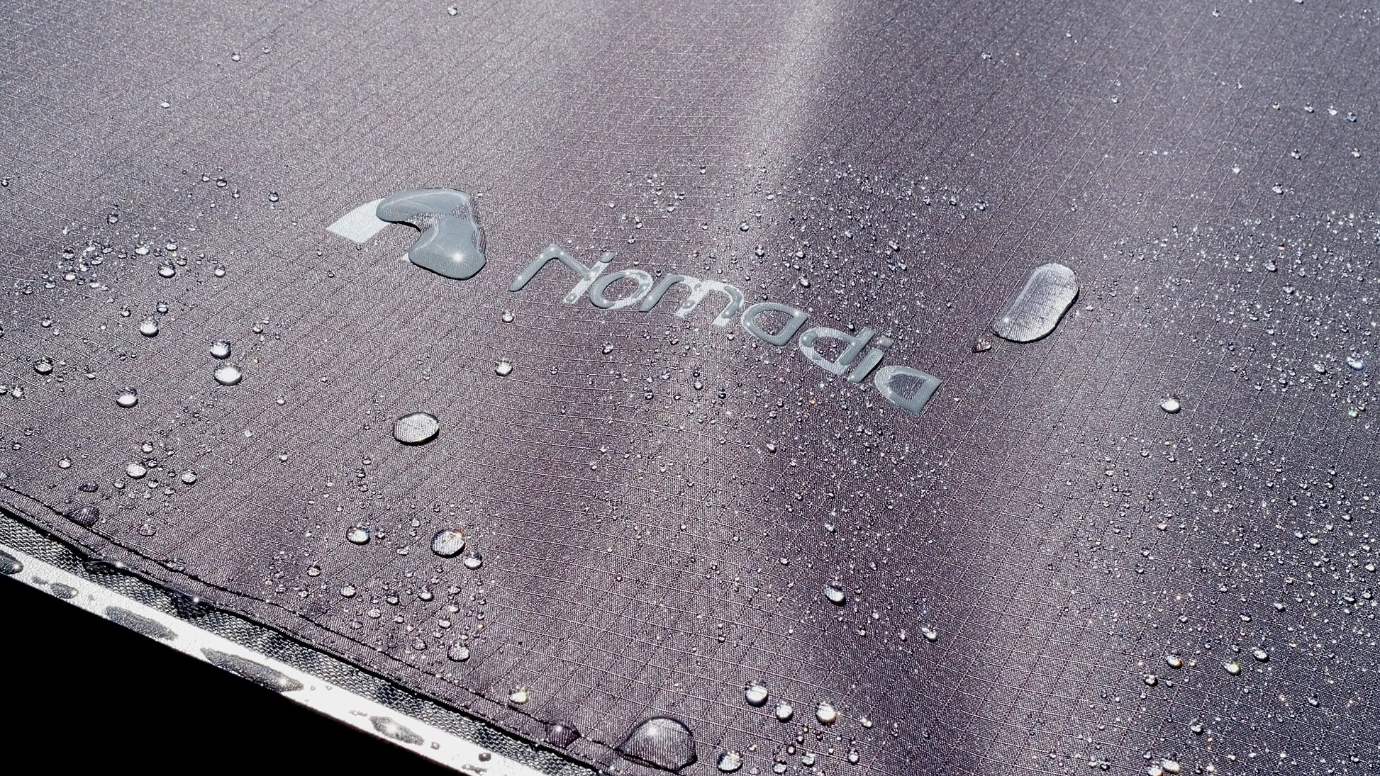 Close-up of Nomadia Glide World's fastest opening awning under rain - all weather ready - durability - overlanding - wildcamping - aluminium awning - easy setup - fast setup awning - strong support