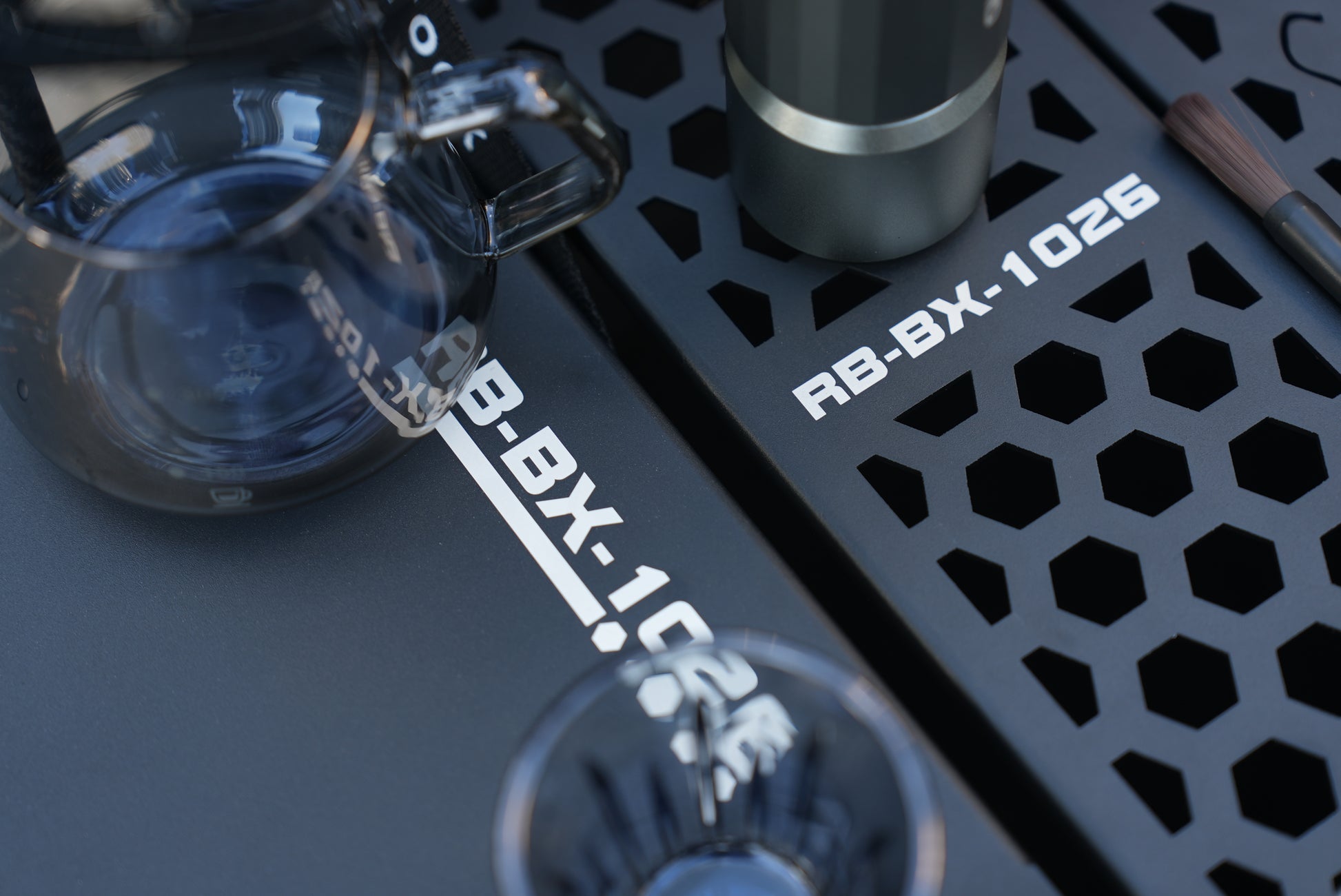 Close-up of a coffee brewing setup using Nomadia ModoBox 2in1 camping table and storage box with a glass carafe and a black metal tray