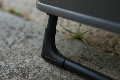 Close-up of a black metal stand on Nomadia ModoBox 2in1 camping table and storage box on rough surface - camping gear - glamping - uk camping