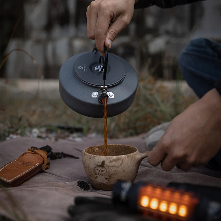 Person pouring coffee from  Nomadia fast boil camping kettle for gas stove into a mug outdoors - portable coffee maker - multiuse -small camping kettle - campervan kettle 