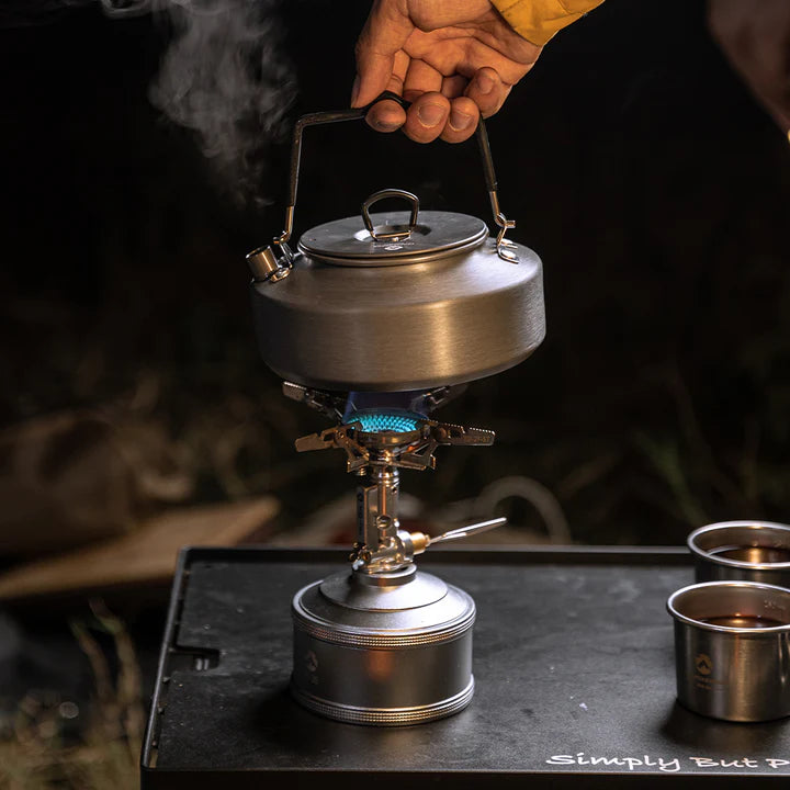 Portable stove with Nomadia fast boil camping kettle for gas stove on top, emitting steam, on a dark background - small camping kettle - campervan kettle - multiuse kettle