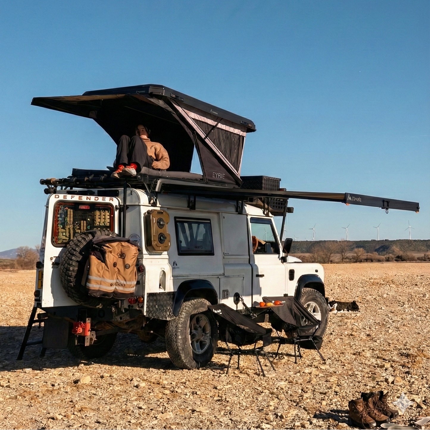 White off-road vehicle with a rooftop tent in a desert landscape