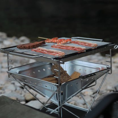 Nomadia's Flamo Portable Folding BBQ Grill and Fire Pit with food being cooked on a natural outdoor setting - wildcamping - camping with a fire - uk camping