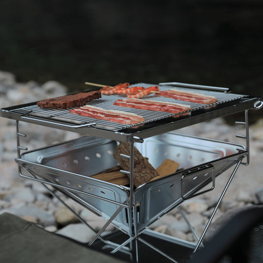 Nomadia's Flamo Portable Folding BBQ Grill and Fire Pit with food being cooked on a natural outdoor setting - wildcamping - camping with a fire - uk camping