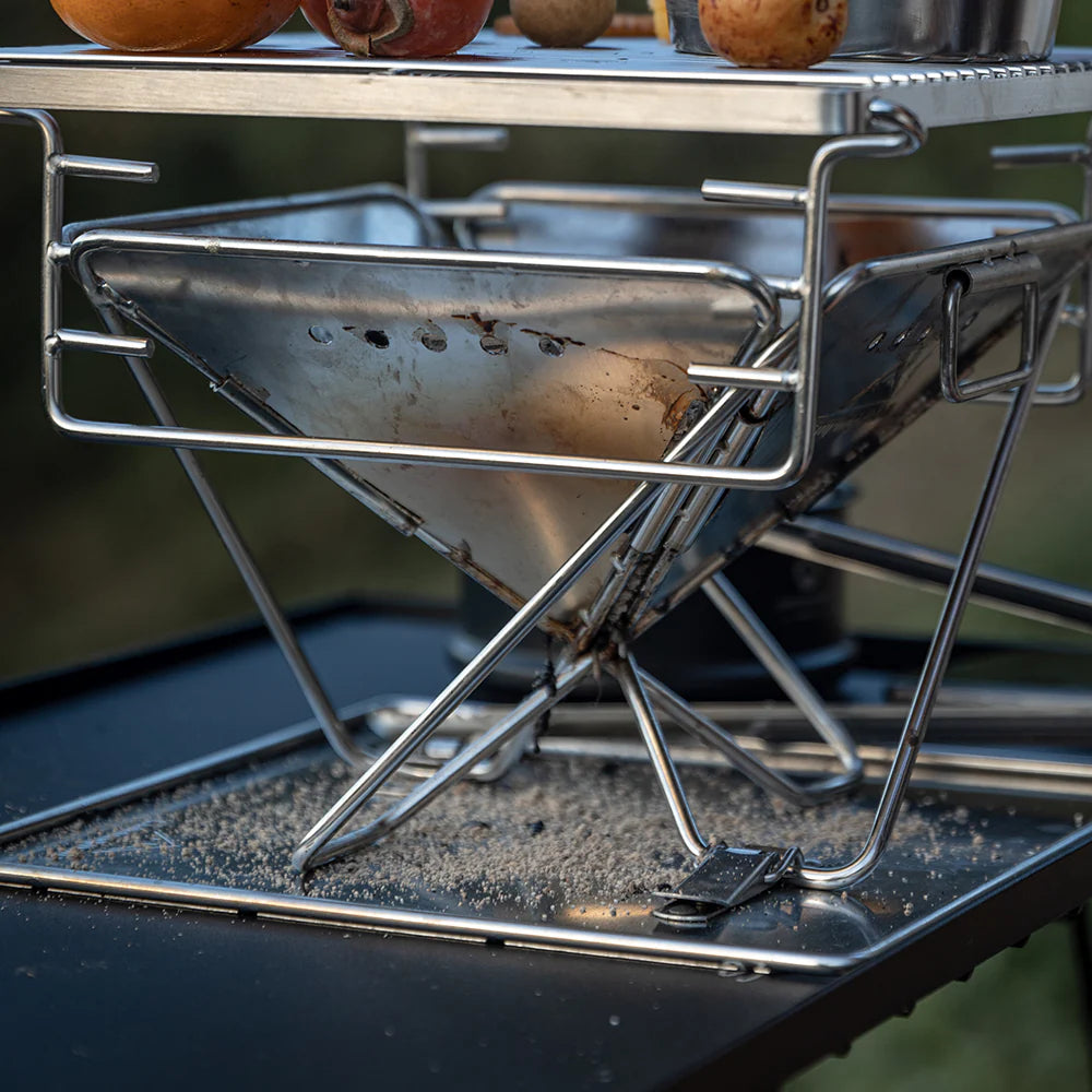 Nomadia's Flamo Portable Folding BBQ Grill and Fire Pit mini with food being cooked on a natural outdoor setting - wildcamping - camping with a fire - uk camping